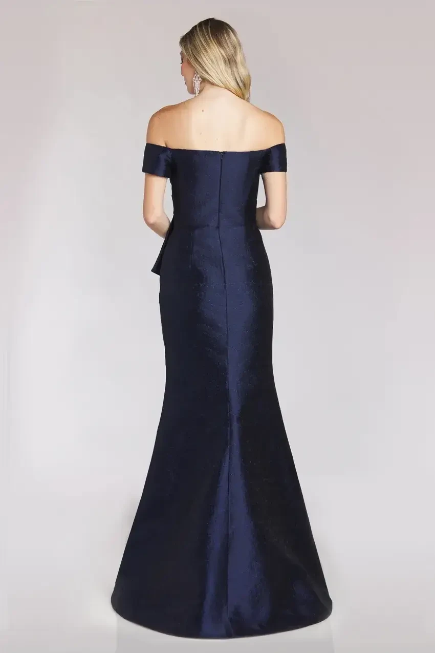 model is wearing an off the shoulder navy evening gown by feriani couture and gia franco