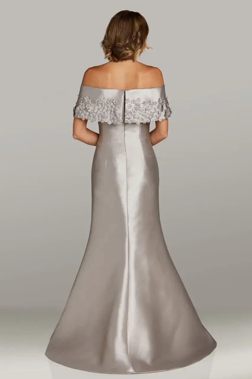 model is wearing an off the shoulder silver evening gown by feriani couture and gia franco