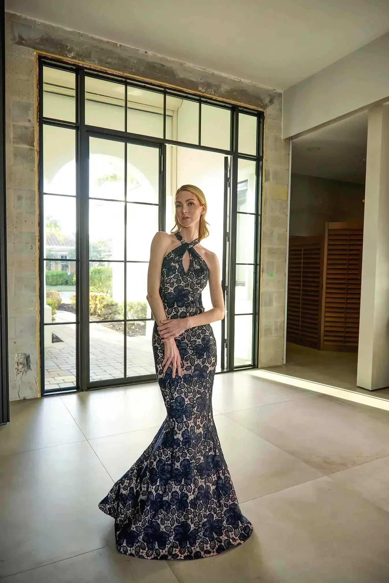 model is wearing a high neck sleeveless black print evening gown