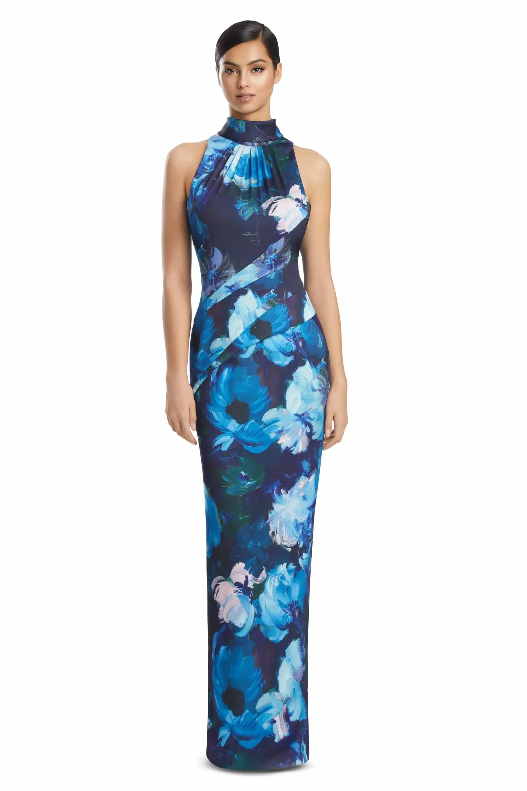 A woman is wearing a long, floral-patterned dress with a halter neck in shades of blue and purple.