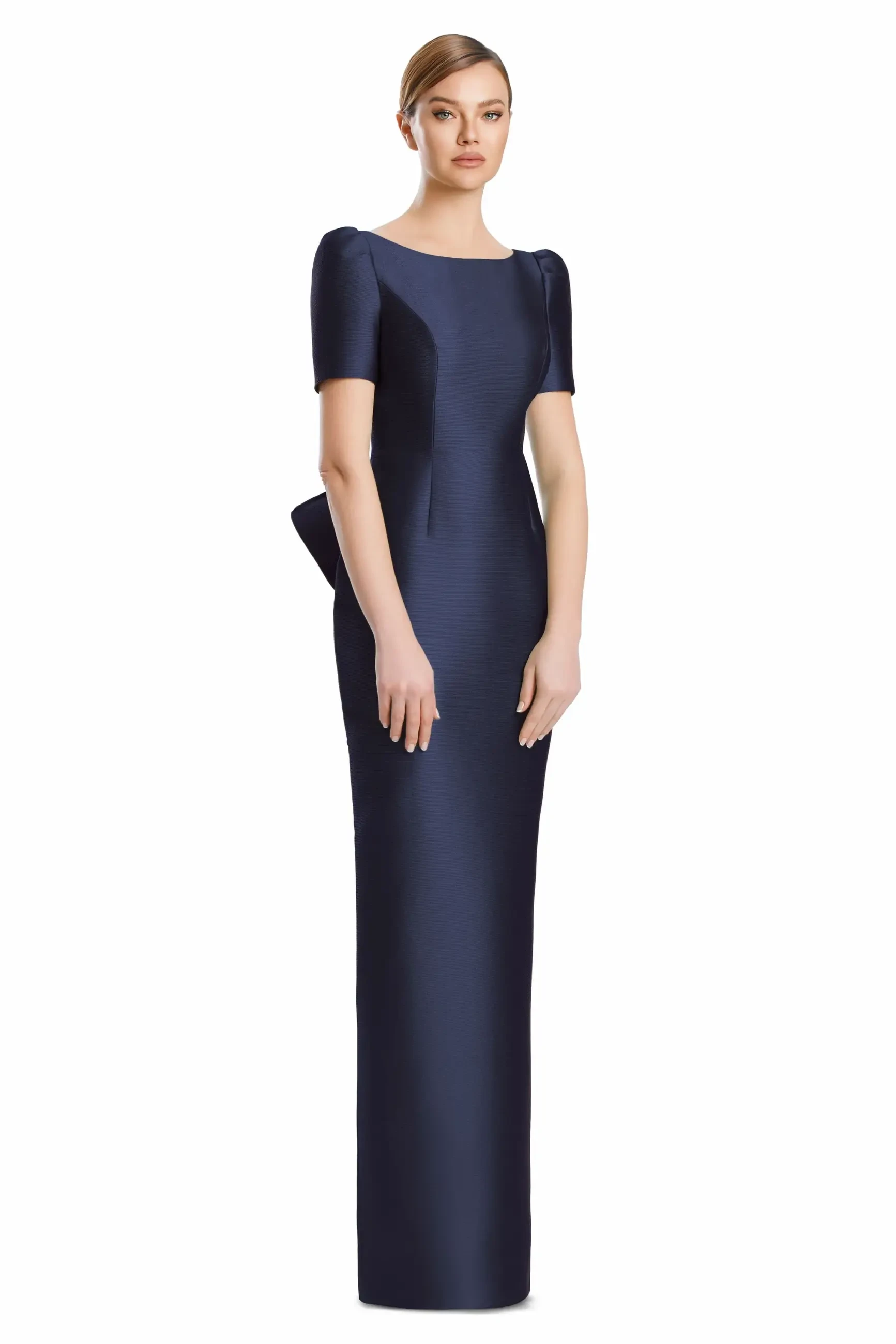 A model wearing a navy blue, form-fitting evening gown with short sleeves and a slight peplum detail at the waist.