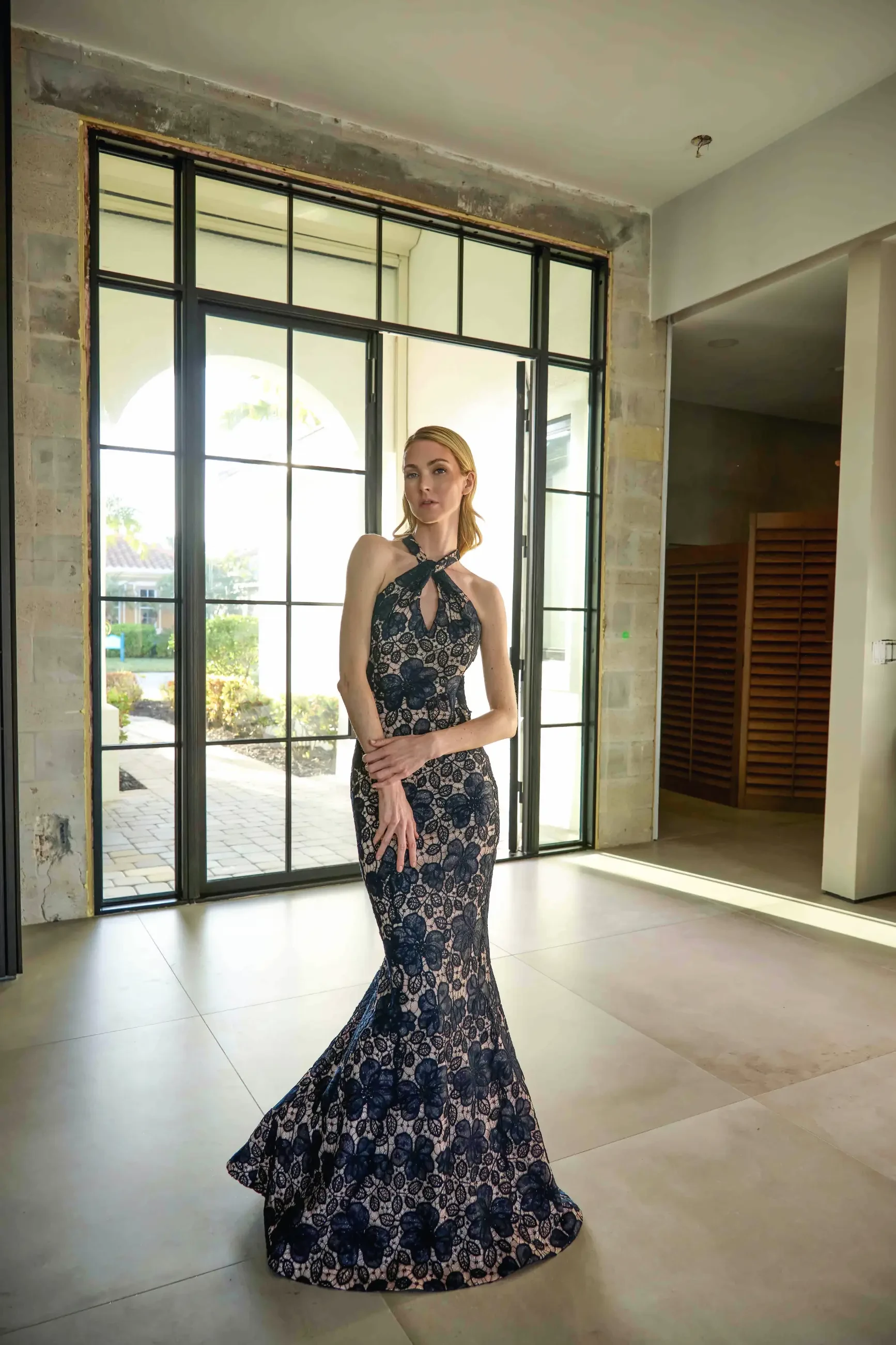 model is wearing a black lace fit and flare evening gown
