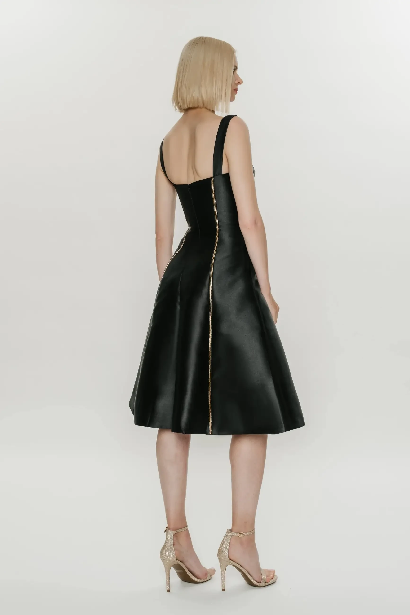 model is wearing a knee length sleeveless black leather dress