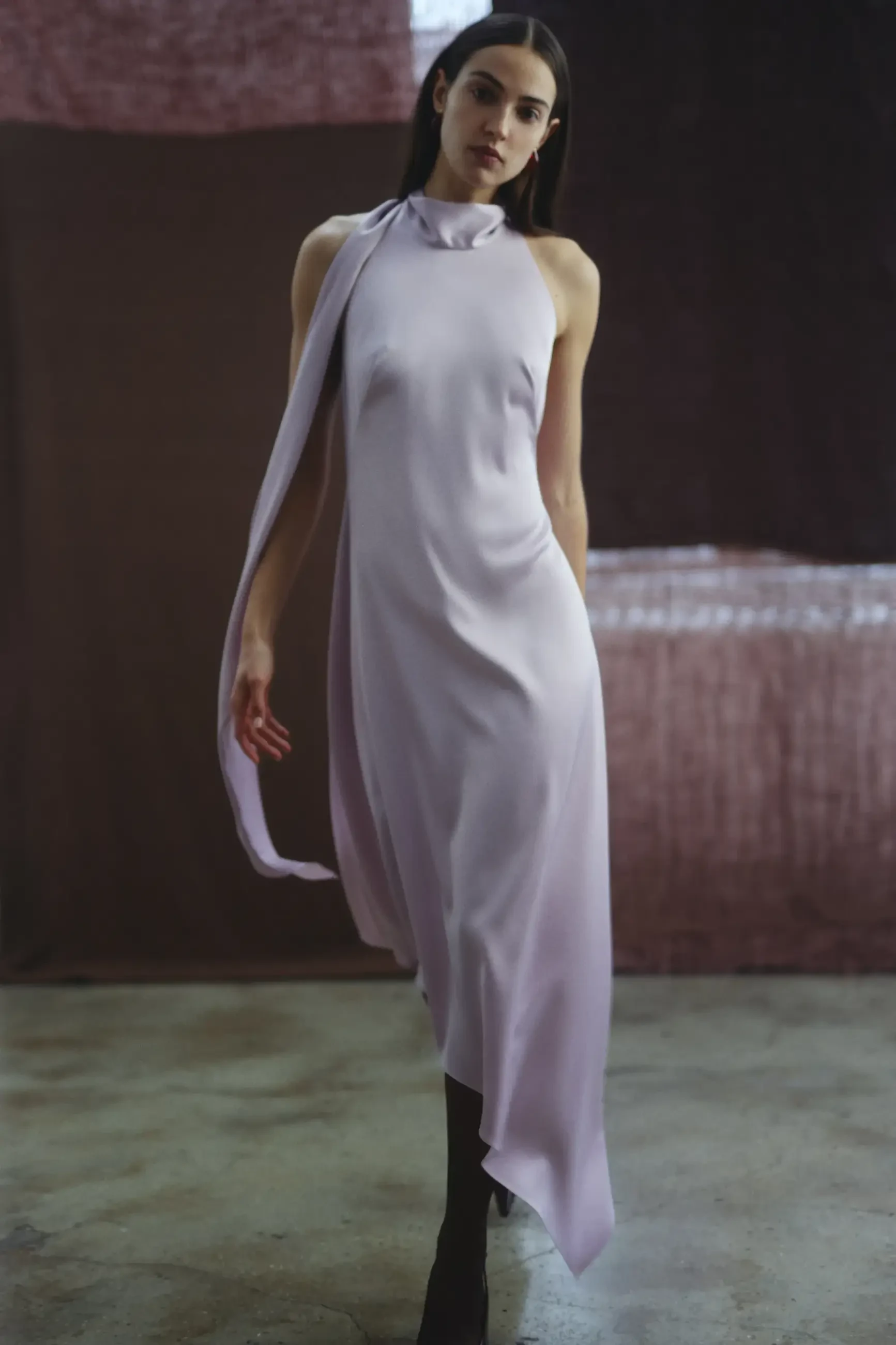 model is wearing a sleeveless purple amsale gown