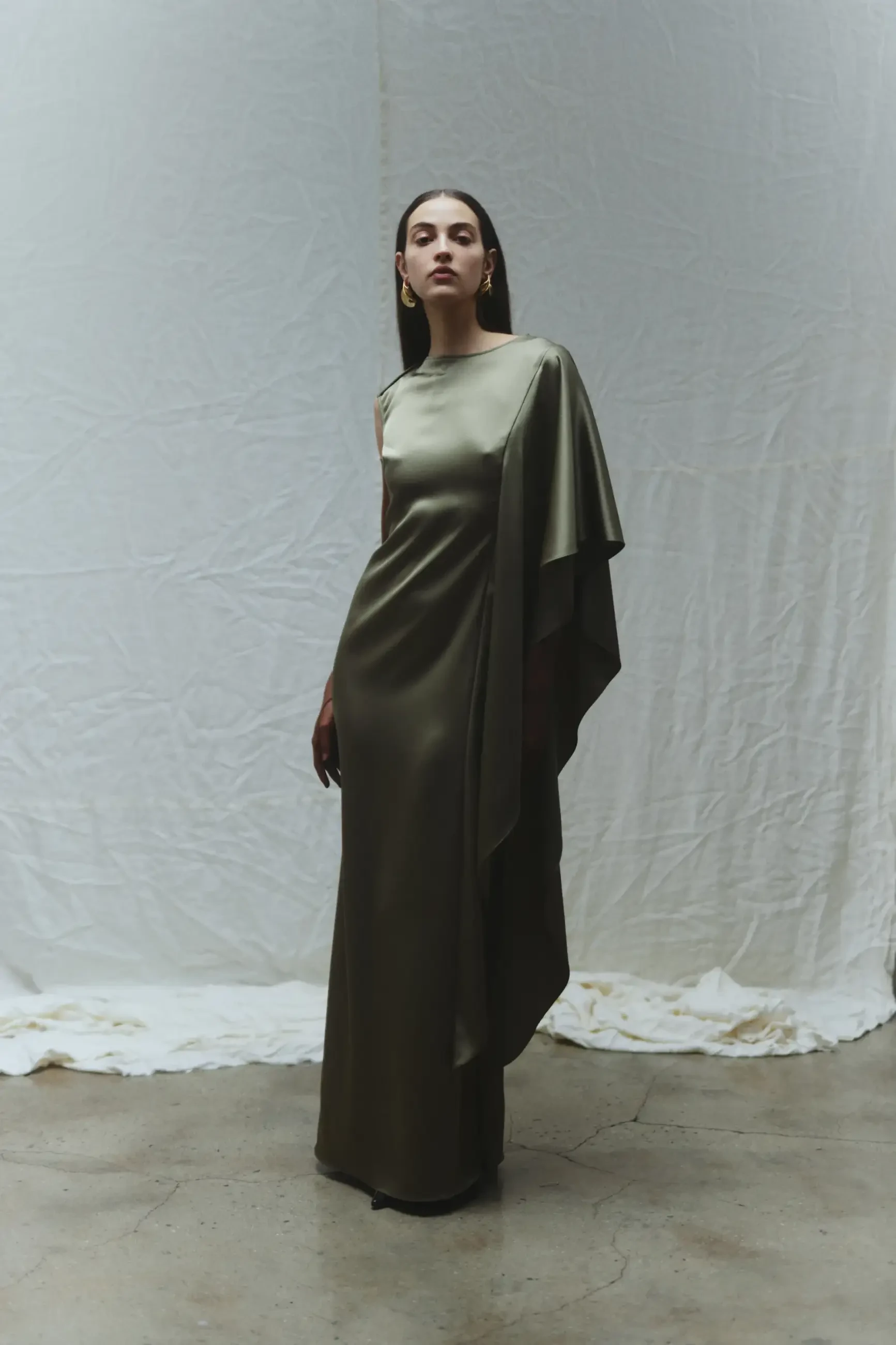 model is wearing a green one shoulder floor length dress